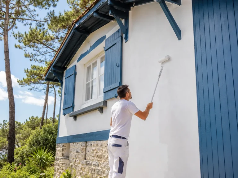 artisan peintre au travail sur une façade à Arcachon
